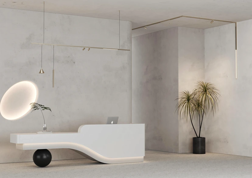 Concrete reception lounge with a nickel-finish magnetic track, spot lights and slim pendants above a sculptural desk