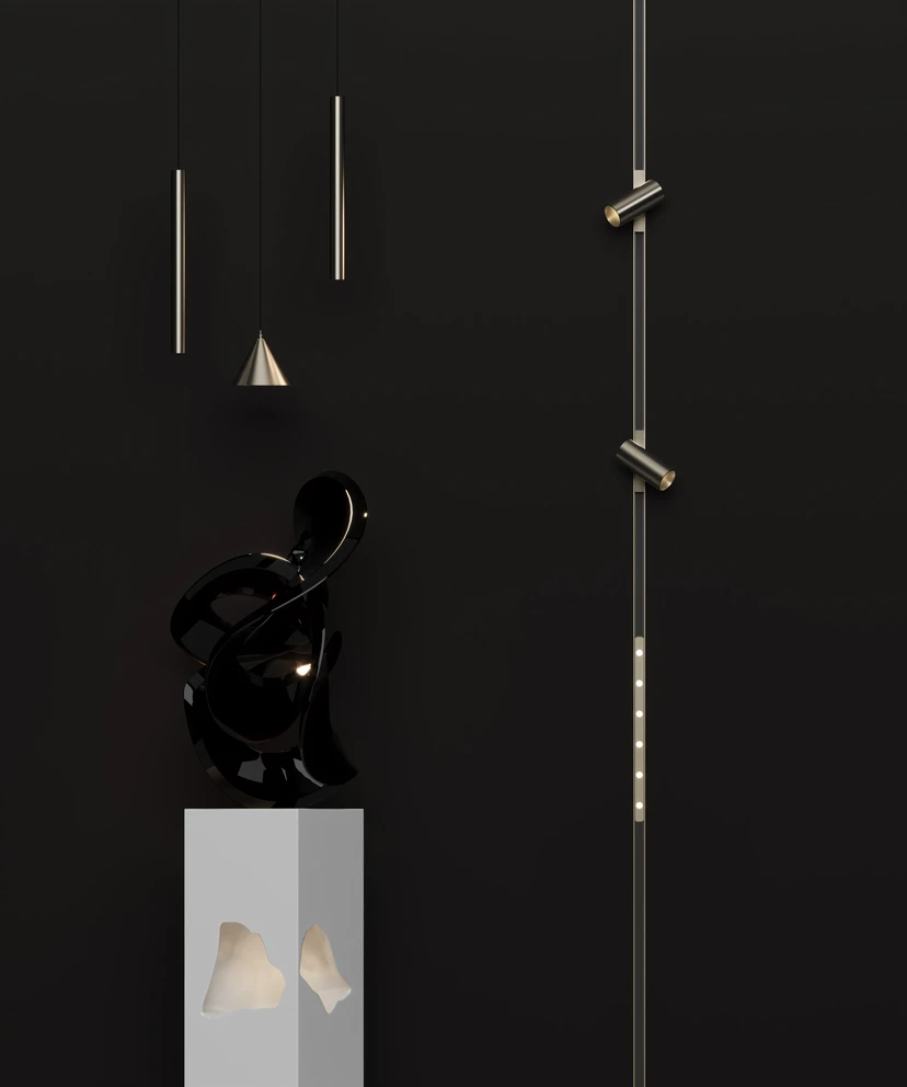 Nickel pendants and a vertical nickel magnetic track with spots against a black wall, beside a sculpture on a plinth