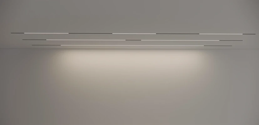 Staggered fine linear lights on a taupe ceiling casting a warm glow across the wall below