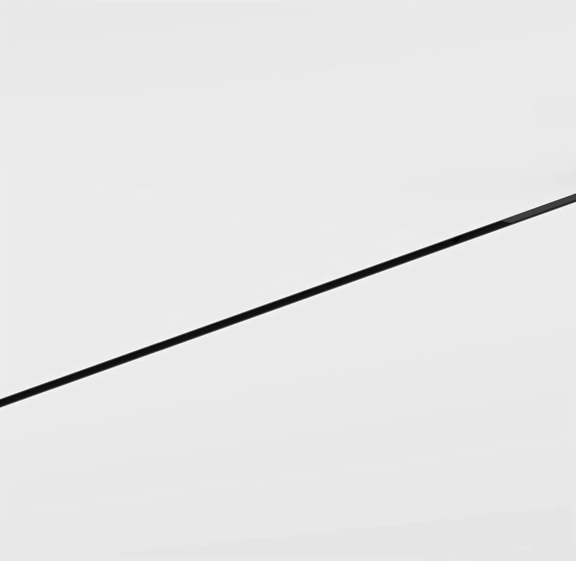 A single slim black track crossing a seamless white ceiling on a bold diagonal